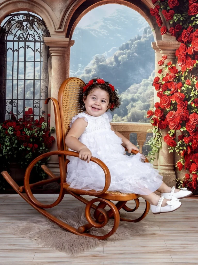 Retrato infantil en una mecedora con decorado floral