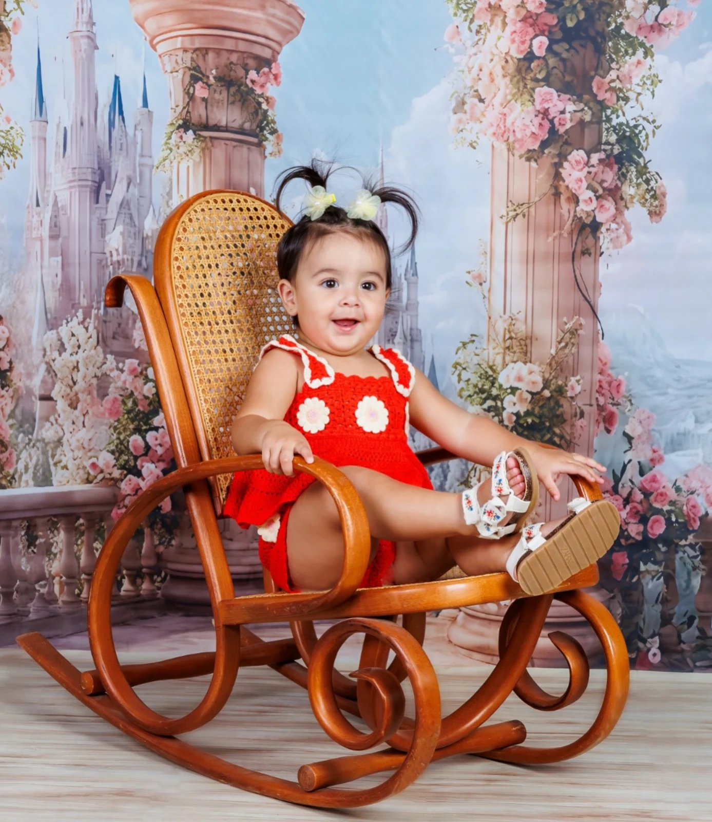 Niña con vestido rojo en una mecedora del estudio