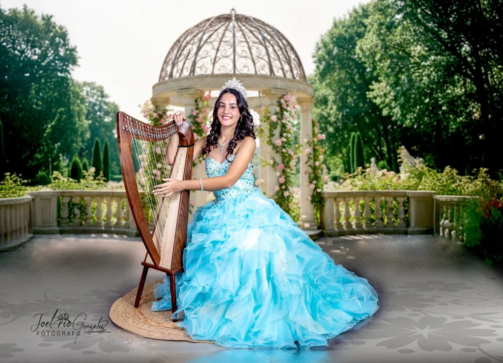 Quinceañera con vestido turquesa y arpa en un jardín