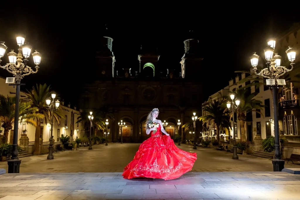 Quinceañera con vestido rojo en una plaza iluminada de Gran Canaria