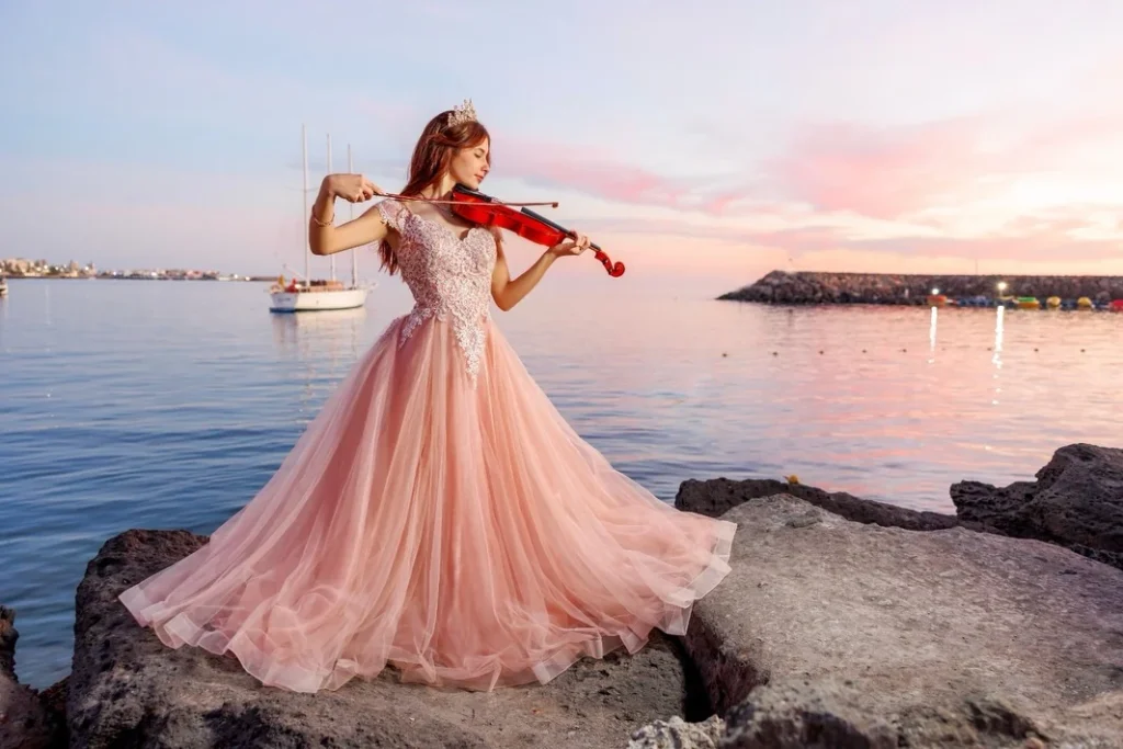 Quinceañera con vestido rosa junto al mar al atardecer en Gran Canaria