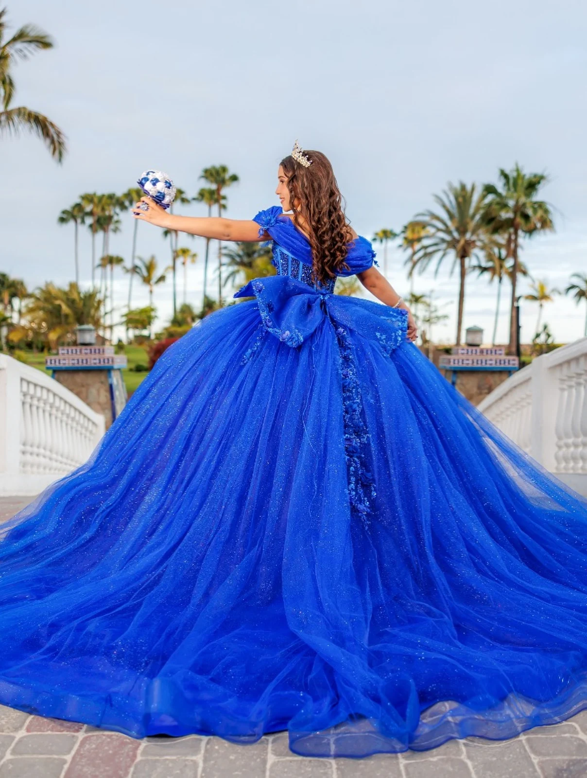Quinceañera con vestido azul y violín entre palmeras en Gran Canaria