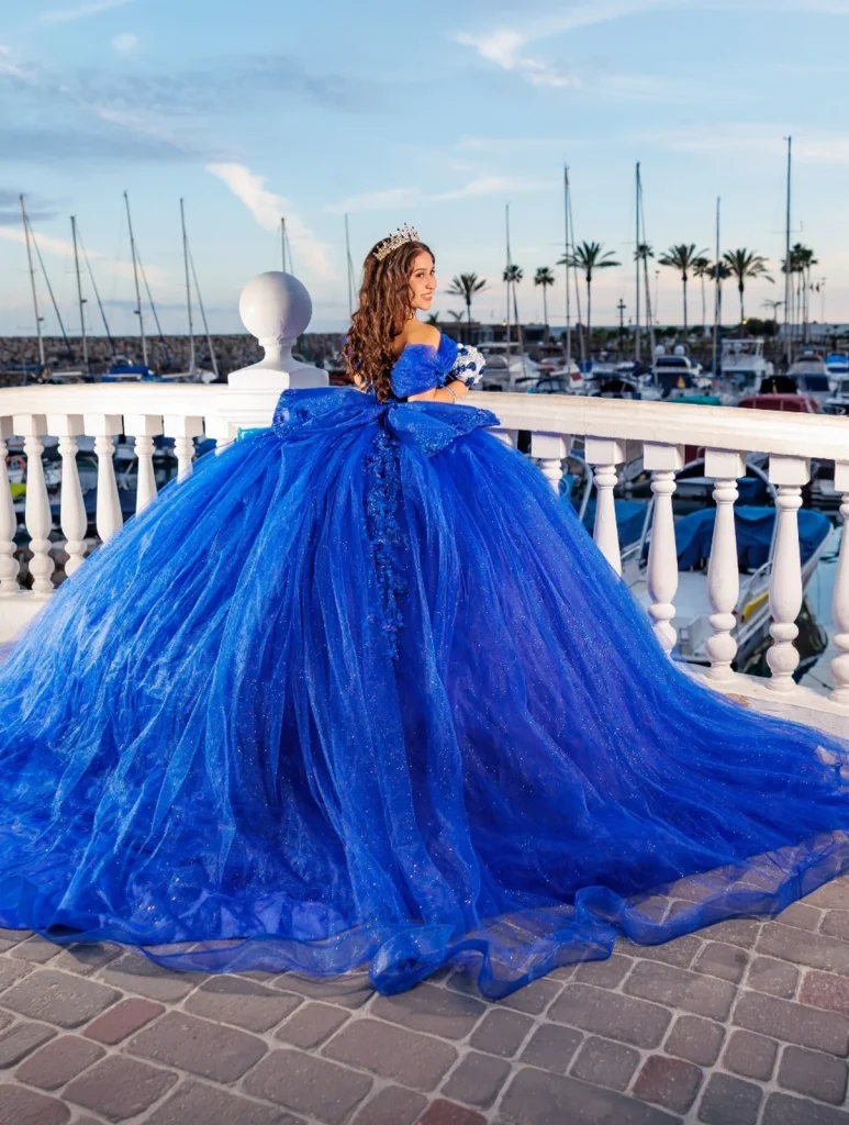 Quinceañera con vestido azul junto a una marina en Gran Canaria
